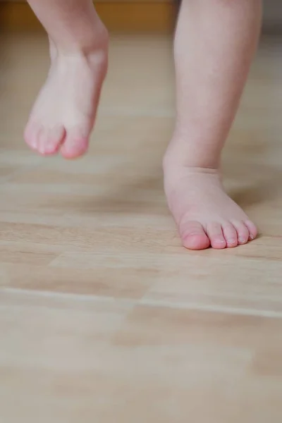 Baby foot running on a tiled floor Stock Photo