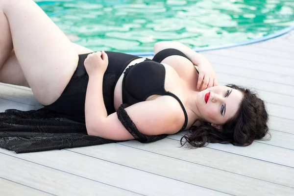 Young beautiful plus size model lying by the pool — Stock Photo, Image