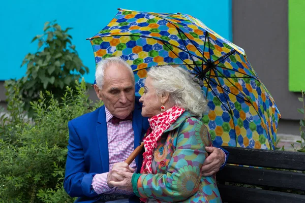 Elegant gekleidetes älteres Paar sitzt auf einer Bank. — Stockfoto
