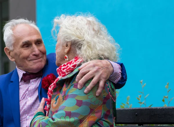 Elegantemente vestito uomo anziano abbraccia le spalle della donna anziana . — Foto Stock