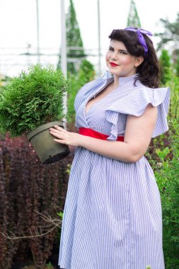 Kız bitki potu bahçede tutar..