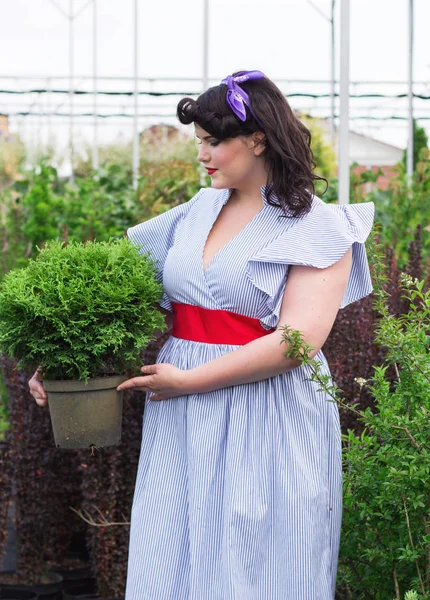 Девушка держит горшок с растением в саду . — стоковое фото