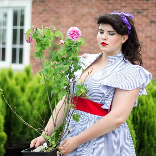 The girl is working in the garden near the house. — Stock Photo, Image