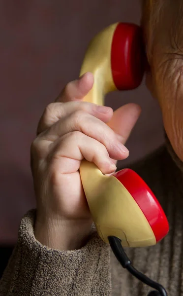 De handset is in de hand van een oude vrouw. — Stockfoto