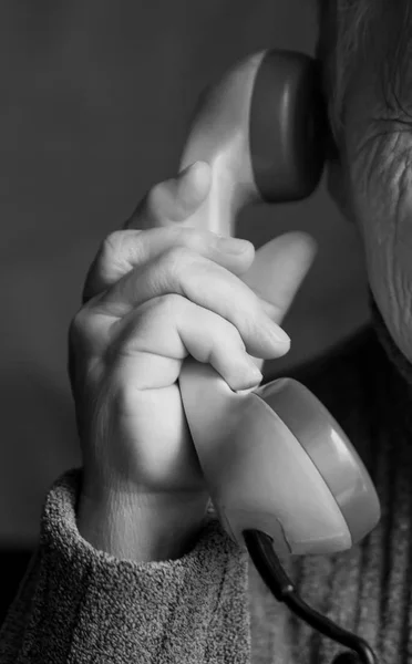 Το ακουστικό είναι στο χέρι του μια ηλικιωμένη γυναίκα. — Φωτογραφία Αρχείου