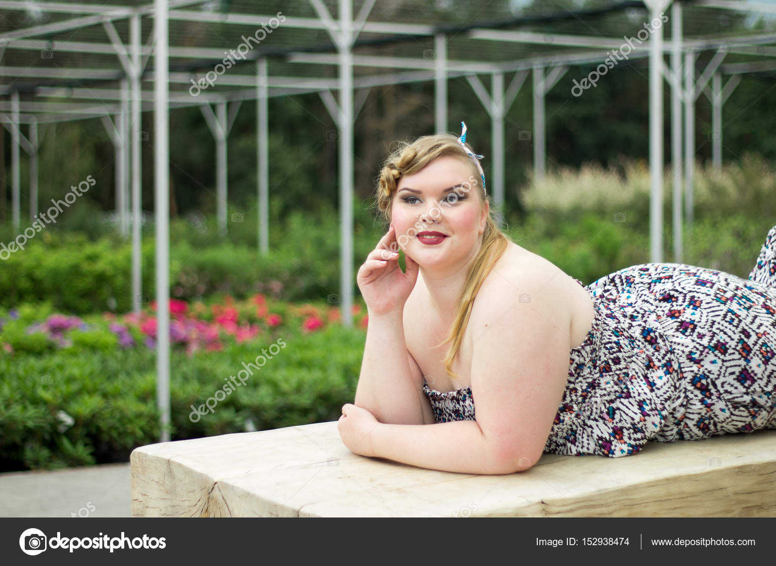 Young beautiful plus size girl is lying on wooden bench. Stock Photo photonatasavina.gmail 152938474