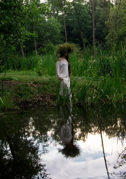 Молодая девушка в венке погружается в воду на народном фестивале — стоковое фото