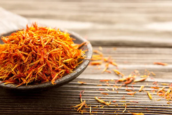 Spice saffron in a wooden spoon on the table. — Stock Photo, Image