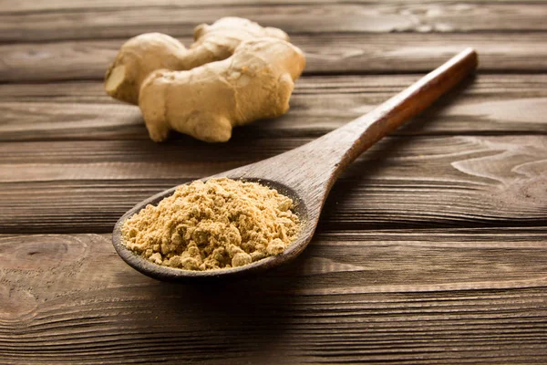 Ginger powder in wooden spoon on wooden table. — Stock Photo, Image