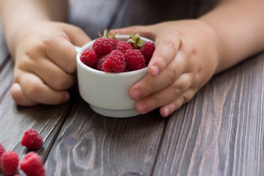  Ahududu bir fincan bebeğin ellerini tutun