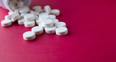 Fazla hap şişe kırmızı zemin üzerine dökülür.. 