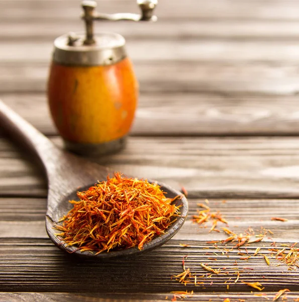 Spice saffron in wooden spoon on wooden backgroundl. Close-up. — Stock Photo, Image