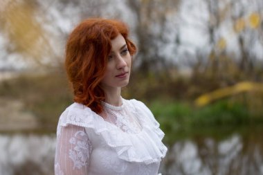 Açık havada sonbaharda Kızıl saçlı güzel genç kadın. 