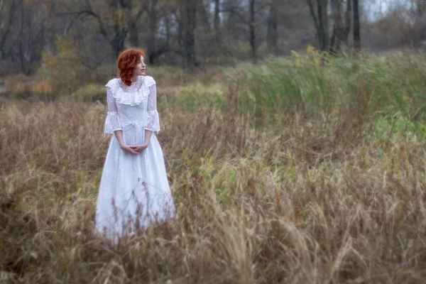 Girl with red hair in a forest in autumn. — Stock Photo, Image