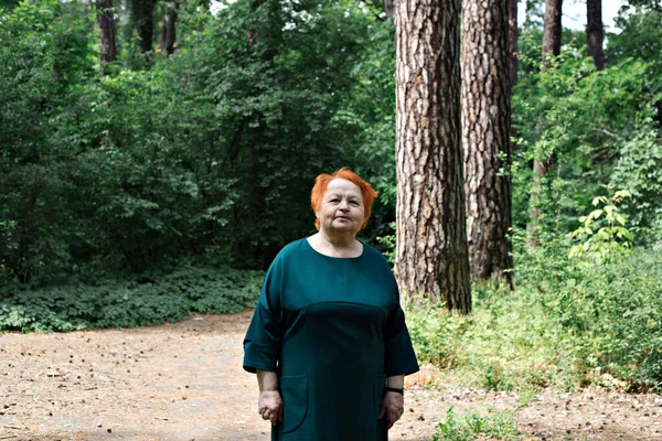 Portrait of a smiling elderly woman. Old woman walks in the park.