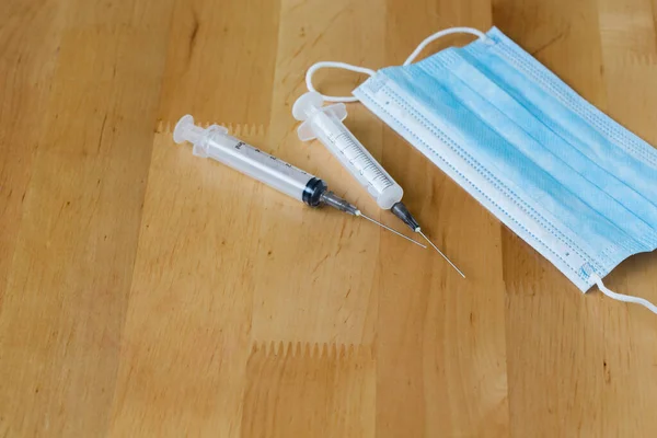 Blaue Medizinische Einweg Mundschutz Und Spritzen Auf Einem Holztisch — Stockfoto