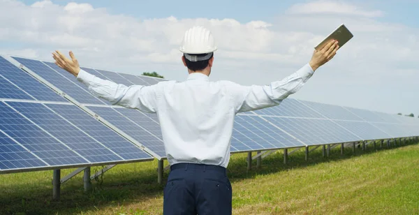 El experto técnico se alegra del éxito en el control remoto de paneles fotovoltaicos solares realiza acciones de rutina para monitorear el sistema utilizando energía renovable limpia Concepto de tecnología de soporte remoto . — Foto de Stock