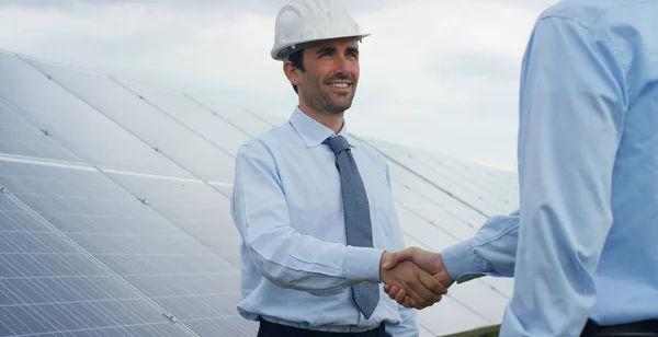 Due tecnici esperti partner nel settore dei pannelli fotovoltaici solari, il telecomando esegue operazioni di routine per monitorare l'impianto utilizzando energia pulita e rinnovabile. Il concetto di tecnologia di supporto remoto . — Foto Stock