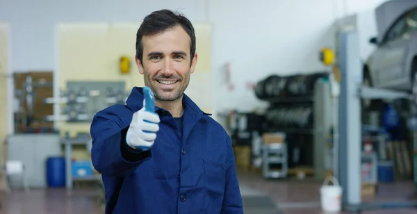 Portrait of a young beautiful car mechanic in a car workshop, in the background of service. Concept: repair of machines, fault diagnosis, repair specialist, technical maintenance and on-board computer — Stock Photo, Image