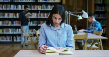 Kitaplığındaki kitap tutan bir arama yaptıktan sonra ve eğitim sonra mutlu gülümseyen güzel bir genç kadın portresi. Konsept: eğitim, portre, Kütüphane ve çalışkan.