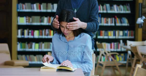 Un paio di amici e fanno battute, si abbracciano e ridono in biblioteca e si amano come segno di amore e amicizia. Concetto: stile di vita, cultura, amicizia e amore — Video Stock