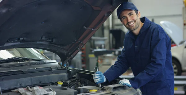 Specialist auto mechanic in the car service, checks the car, engine, engine, carburetor. Concept: repair of machines, fault diagnosis, repair specialist, technical maintenance and on-board computer. — Stock Photo, Image