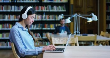Kütüphanede ders, kitap okuma veya tam bir sessizlik ve gevşeme bilgisayarda müzik dinlemek kadın ve genç erkek bir grup. Kültür, eğitim, dinlenme ve çalışma kavramı