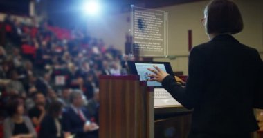 kadın bir fütüristik ve teknoloji oditoryum bir kongre ekonomi üzerinde seyirci için bir konuşma tutar ve vade onların business.concept:world Ekonomi, fütüristik konferans, hologram, teknoloji