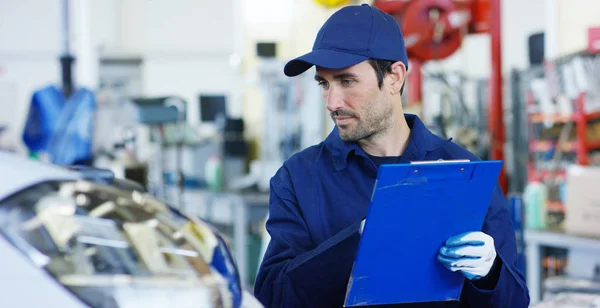 Specialist (auto control), an auto mechanic in a car service, checks the machine diagnostics. Concept: repair of machines, fault diagnosis, repair specialist, technical maintenance, on-board computer. — Stock Photo, Image