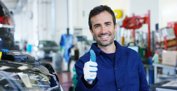 Retrato de um carro bonito jovem mecânico em uma oficina de carro, no fundo de um serviço de carro Conceito de reparação de máquinas, diagnóstico de falhas, especialista em reparação, manutenção técnica a bordo do computador — Fotografia de Stock