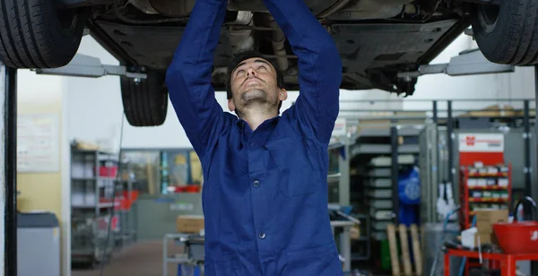 Specialist auto mechanic in the car service, repairs the car, makes transmission and wheels. Concept: repair of machines, fault diagnosis, repair specialist, technical maintenance, on-board computer. — Stock Photo, Image