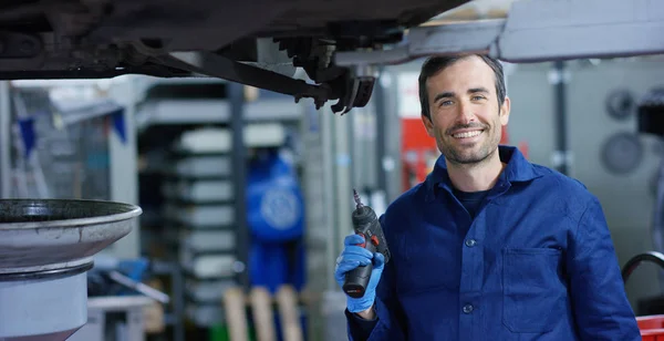 Portrait of a young beautiful car mechanic in a car workshop, in the background of a car service Concept repair of machines, fault diagnosis, repair specialist, technical maintenance on-board computer — Stock Photo, Image