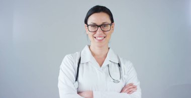 Beyaz önlük ve gülümseyerek kameraya beyaz arka plan üzerinde seyir stetoskop ile kadın doktor portresi. Konsept: doktor, sağlık, tıp sevgisi.