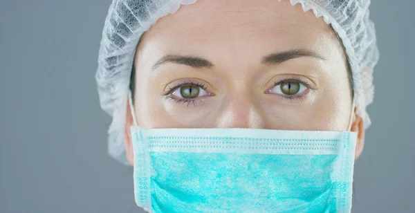 Närbild porträtt av en kvinna kirurg eller läkare med mask redo för operation på sjukhus eller klinik. — Stockfoto