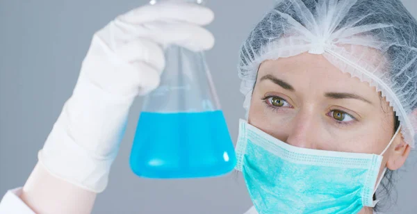 Bir laboratuarda, pipetli bir bilim adamı test tüplerindeki DNA ve molekülleri ayırmak için renkli bir sıvıyı analiz eder. Konsept: araştırma, biyokimya, doğa, ilaç — Stok fotoğraf
