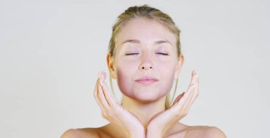 Gülümseyen ve krem, beyaz bir arka plan üzerinde sonra makyaj, olmadan kamera bakıyor güzel bir genç kız portresi. Konsept: doğal güzellik, gençlik, Cilt Bakımı, her zaman genç, kendini sevmeyi.