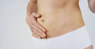 Genç kız smear beyaz zemin üzerine onu güzel, mükemmel body(waist) krem. Konsept: vejetaryen, diyet, doğru beslenme, spa prosedürler, taze, fitness, biyo ürünleri, vücut bakımı, mükemmel cilt.