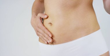 O gösterilen bir genç kızın güzel vücut mükemmel, beyaz arka plan üzerinde mevcuttur. Kavram: diyet, doğru beslenme, spor vücut, ince vücut, kendiniz üzerinde çalışmak, kendini sev, elde etmek, vücut için bakım