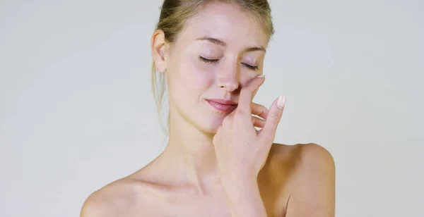 Portrait d'une belle jeune fille souriante et regardant la caméra, sans maquillage, après crème, sur un fond blanc. Concept : beauté naturelle, jeunesse, soin de la peau, toujours jeune, s'aimer soi-même . — Photo