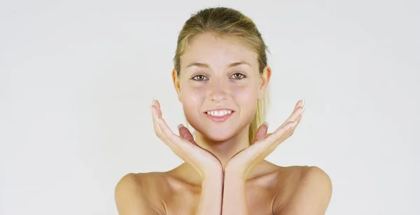 Portrait d'une belle jeune fille souriante et regardant la caméra, sans maquillage, après crème, sur un fond blanc. Concept : beauté naturelle, jeunesse, soin de la peau, toujours jeune, s'aimer soi-même . — Photo