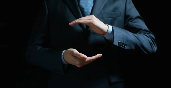 Un hombre de negocios en un traje y corbata con la mano extendida para la implementación de gráficos futuristas. Concepto: negocio, gráfico, holografía, canal alfa. —  Fotos de Stock