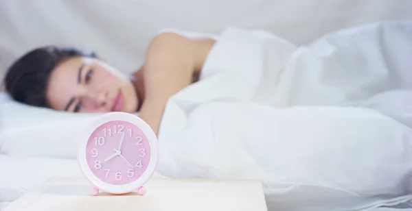 Egy egyszerű munkanap, egy gyönyörű fiatal lány alszik egy meleg ágy, borított egy puha meleg fehér takaró, fehér alapon. — Stock Fotó