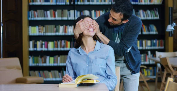 Un par de amigos y bromas, abrazos y risas en la biblioteca y se aman como un signo de amor y amistad. Concepto: estilo de vida, cultura, amistad y amor — Foto de Stock