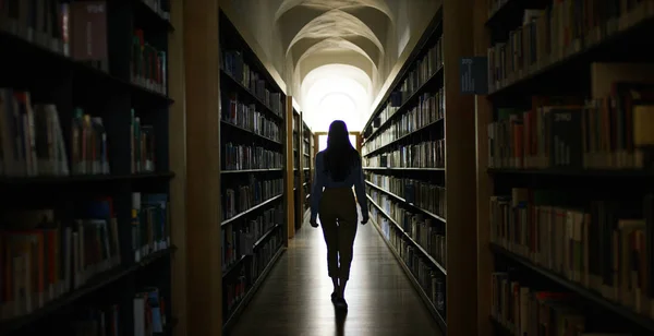 Retrato de una hermosa joven sonriendo feliz en una biblioteca sosteniendo libros después de hacer una búsqueda y después de estudiar. Concepto: educativo, retrato, biblioteca y estudioso . — Foto de Stock