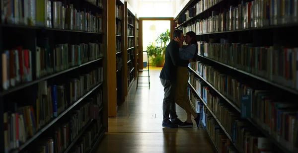 En una biblioteca, una pareja enamorada, besándose y abrazándose y arrastrada por la pasión y el amor. Concepto: Amor, sueño, beso . — Foto de Stock