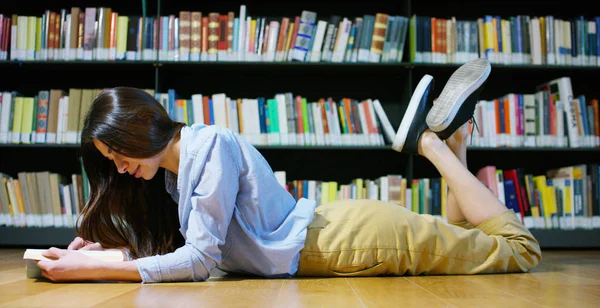 Портрет красивой молодой женщины, улыбающейся счастливой в библиотеке, держащей книги после поиска и после учебы. Концепция: образовательная, портретная, библиотечная и учебная . — стоковое фото