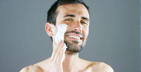 A beautiful portrait of man before to shave using shaving foam for better perfect shave and protect your skin from irritation. Concept: barber, shaving cream and man. — Stock Photo, Image