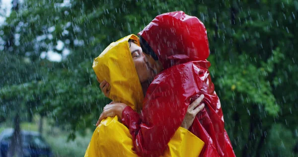 2 つのティーンエイ ジャーや大人の愛好家のような雨の中でキスしています。幸せなカップル生活、周りの自然の。自然と幸せな生活の概念。冒険、純度. — ストック写真