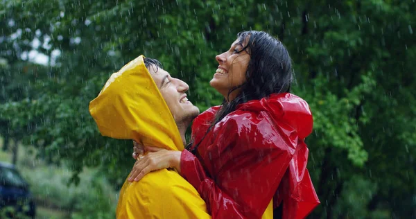 Dos adolescentes o adultos se besan bajo la lluvia como amantes. Feliz pareja de vida y naturaleza alrededor. concepto de la naturaleza y la vida feliz. Aventura, pureza . — Foto de Stock