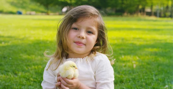 Los mejores momentos de la vida, las chicas dulces, juega en el parque con pollitos (amarillo), en el fondo de la hierba verde y los árboles, el concepto: los niños, el amor, la ecología, el medio ambiente, la juventud . — Foto de Stock